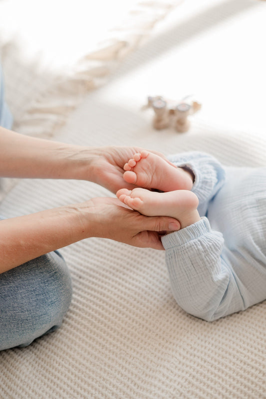 Eine Frau hält die Füße ihres Babys