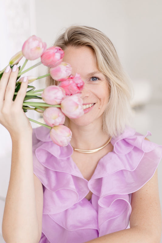 Frau hält sich Strauß Tulpen vors Gesicht